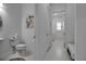Bright hallway leading to the laundry room featuring a white toilet and a white vanity at 8541 Coastal Palms Gln, Parrish, FL 34219