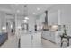 A modern, all-white kitchen features an island with pendant lighting and stainless steel appliances at 8541 Coastal Palms Gln, Parrish, FL 34219