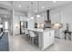 A modern, all-white kitchen features an island with pendant lighting and stainless steel appliances at 8541 Coastal Palms Gln, Parrish, FL 34219