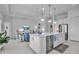 Open-concept kitchen with stainless steel appliances, pendant lights, and a clear view of the comfortable living area at 8541 Coastal Palms Gln, Parrish, FL 34219