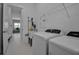 Bright laundry room with appliances, sink, storage, and access to the rest of the house at 8541 Coastal Palms Gln, Parrish, FL 34219