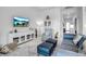Bright living room features a blue sofa, decor cabinet, stylish chairs and large TV for relaxing and entertainment at 8541 Coastal Palms Gln, Parrish, FL 34219