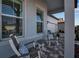 Inviting covered porch with rocking chairs and a brick paver walkway, perfect for enjoying the outdoors at 8541 Coastal Palms Gln, Parrish, FL 34219