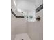 Modern shower featuring white tiling, black accents, and glass enclosure for a sleek and contemporary design at 8541 Coastal Palms Gln, Parrish, FL 34219