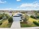 Aerial view of a well-maintained home showcasing a lush green lawn, landscaping, and a driveway at 11231 Woodlake Way, Parrish, FL 34219