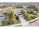 Aerial view of a well-maintained home with a dark roof, surrounded by lush greenery and neighborhood streets at 11231 Woodlake Way, Parrish, FL 34219