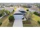 Aerial view of a beautiful single-story home, showcasing its dark roof, and landscaped surroundings at 11231 Woodlake Way, Parrish, FL 34219