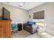 Cozy bedroom features a daybed, comfortable seating, and a bright window overlooking the yard at 11231 Woodlake Way, Parrish, FL 34219