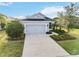 Charming single-story home featuring a well-manicured lawn, gray exterior, and a two-car garage at 11231 Woodlake Way, Parrish, FL 34219