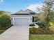 Inviting single-story home with a gray exterior, complemented by manicured landscaping and a two-car garage at 11231 Woodlake Way, Parrish, FL 34219
