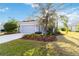 Charming single-story home with a well-manicured lawn, vibrant flower beds, and attached two-car garage at 11231 Woodlake Way, Parrish, FL 34219