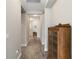 Neutral-toned hallway featuring wood-look tile floors, recessed lighting, and elegant, decorative wooden cabinet at 11231 Woodlake Way, Parrish, FL 34219