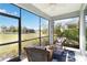 Inviting screened lanai with wicker chairs, a ceiling fan, and views of the landscaped backyard at 11231 Woodlake Way, Parrish, FL 34219