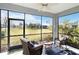 Relaxing screened lanai with two cushioned wicker chairs, a ceiling fan, and views of the backyard at 11231 Woodlake Way, Parrish, FL 34219