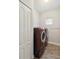 A dedicated laundry room features modern washer and dryer units with tiled floors at 11231 Woodlake Way, Parrish, FL 34219