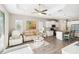 Open-concept living area features a bright kitchen, cozy seating, and wood-look tile flooring at 11231 Woodlake Way, Parrish, FL 34219