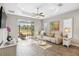 Bright living room featuring wood-look tile flooring, comfortable seating, and a screened patio with backyard view at 11231 Woodlake Way, Parrish, FL 34219