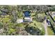 Aerial view of property featuring a home, pool, large driveway and a pond with a fountain at 1521 67Th Street E Ct, Bradenton, FL 34208