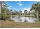 Picturesque view of home from across a pond with a fountain at 1521 67Th Street E Ct, Bradenton, FL 34208
