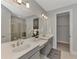 Modern bathroom with double sinks, large mirror, quartz countertops, and glass-enclosed shower and walk in closet at 16119 Fortezza Dr, Bradenton, FL 34211