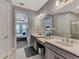 Elegant bathroom with double sinks, a large mirror, quartz countertop and view into the beautifully decorated bedroom at 16119 Fortezza Dr, Bradenton, FL 34211