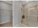 Bright bathroom featuring a glass shower, walk-in closet, and vanity with modern fixtures and shelving at 16119 Fortezza Dr, Bradenton, FL 34211