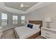 Bright bedroom featuring large windows, tray ceilings, and a comfortable bed with stylish bedside tables at 16119 Fortezza Dr, Bradenton, FL 34211