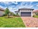 Beautiful single Gathering home with a gray two car garage, paver driveway, and professionally landscaped front yard at 16119 Fortezza Dr, Bradenton, FL 34211