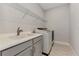 Functional laundry room equipped with modern washer, dryer, and ample storage at 16119 Fortezza Dr, Bradenton, FL 34211