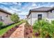 Side view of a single Gathering home with a paver walkway and lush landscaping leading to the backyard at 16119 Fortezza Dr, Bradenton, FL 34211
