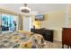 Sunny bedroom with sliding glass doors to other rooms and a TV mounted on the wall at 198 Salem Nw Ave, Port Charlotte, FL 33952