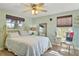 Cozy bedroom with a brass bed frame, ceiling fan, and natural light from the windows at 198 Salem Nw Ave, Port Charlotte, FL 33952