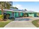 Beautiful home with green exterior, well-manicured landscaping, mature palm trees, metal roof, solar panels and long driveway at 198 Salem Nw Ave, Port Charlotte, FL 33952