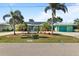 Inviting home featuring lush landscaping, mature palm trees, an extended driveway, solar panels and an attached garage at 198 Salem Nw Ave, Port Charlotte, FL 33952
