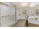 Bathroom showcases white tiled shower, double sink vanity, and relaxing soaking tub at 2630 Moss Oak Dr # 50, Sarasota, FL 34231