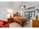 Spacious primary bedroom features sliding glass door, ceiling fan, and king bed at 2630 Moss Oak Dr # 50, Sarasota, FL 34231