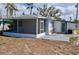 Cozy home featuring a screened-in porch, a white exterior, and a well-maintained yard at 321 40Th Street Nw Ct, Bradenton, FL 34209
