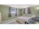 A cozy bedroom featuring two windows providing ample natural light and light-green walls with decorative wallpaper border at 3365 7Th St, Sarasota, FL 34237