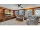 Cozy living room featuring wood paneling, a ceiling fan, and comfortable seating near bright windows at 3365 7Th St, Sarasota, FL 34237