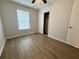 Bedroom featuring a large closet, a window with blinds, and wood-look flooring at 3707 Carroway St, Tampa, FL 33619