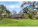 Expansive backyard view showcasing the screened pool enclosure surrounded by mature trees and lush greenery at 3783 Beneva Oaks Blvd, Sarasota, FL 34238