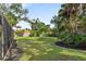 Lush green backyard with manicured lawn and mature trees surrounding the screened pool enclosure at 3783 Beneva Oaks Blvd, Sarasota, FL 34238