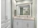 Bright bathroom featuring double vanity with white cabinetry and stone countertop plus large framed mirror at 3783 Beneva Oaks Blvd, Sarasota, FL 34238
