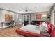 Spacious bedroom with red bed frame, wood floors, ceiling fan, and access to balcony through French doors at 3783 Beneva Oaks Blvd, Sarasota, FL 34238
