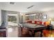 Game room with a pool table, cozy red sectional, bar seating and access to the outdoor pool area at 3783 Beneva Oaks Blvd, Sarasota, FL 34238