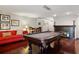 Game room with a pool table, red sectional, fireplace and dark wood flooring at 3783 Beneva Oaks Blvd, Sarasota, FL 34238