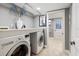 Modern laundry room with gray walls, stainless steel washer and dryer, and decorative touches at 3783 Beneva Oaks Blvd, Sarasota, FL 34238
