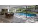 Captivating view of the screened pool area with a dining table, comfortable seating, and lush backyard landscaping at 3783 Beneva Oaks Blvd, Sarasota, FL 34238