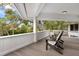 Charming porch with wooden floors, white railing, and comfortable Adirondack chairs at 3783 Beneva Oaks Blvd, Sarasota, FL 34238
