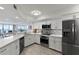 Well-lit kitchen featuring white cabinetry, stainless steel appliances, and water views at 5279 Isla Key S Blvd # 113, St Petersburg, FL 33715
